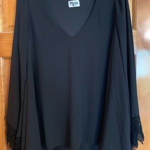 Long black v neck top with detailed sleeves.